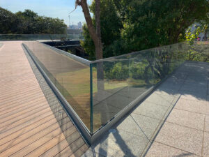 Guarda corpo de vidro pode ser utilizado em diversos ambientes | guarda corpo de vidro em um jardim com árvore | Sanglass SP